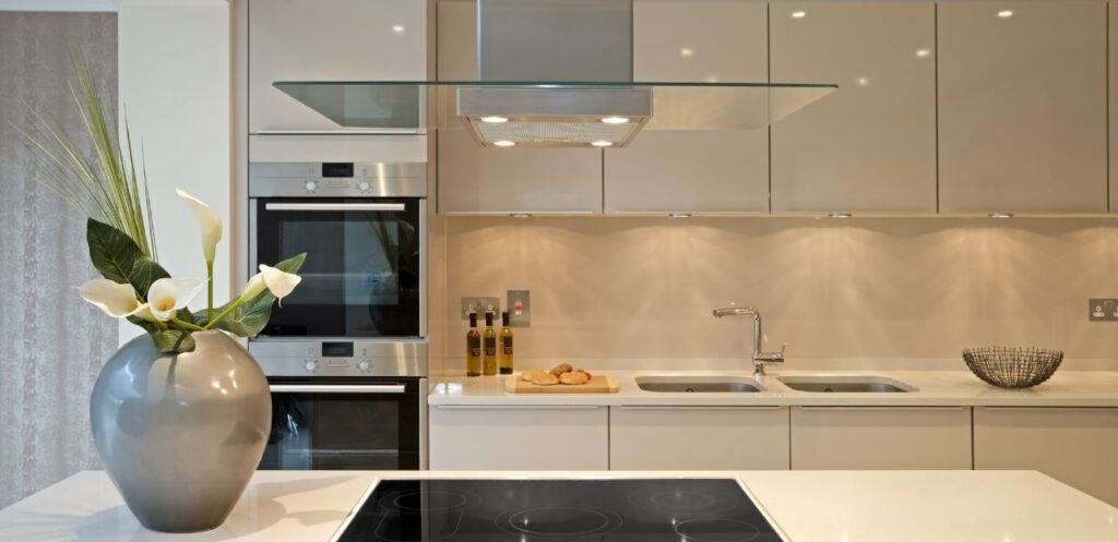 Modern handleless kitchen with an induction hob and integrated ovens