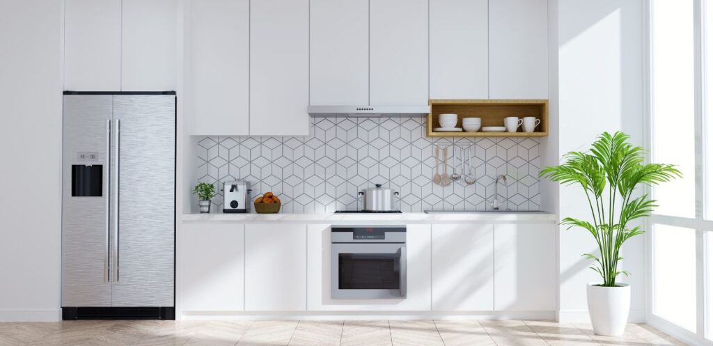 White kitchen units with patterned tile splashback and integrated appliances