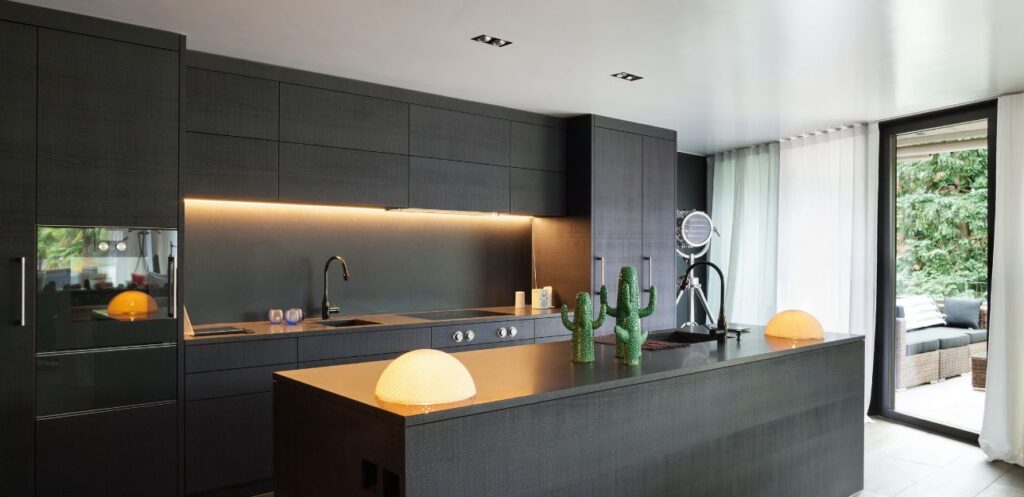 Dark modern kitchen with an island and wood worktop in a Wigan home